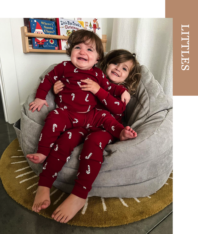 Millie and Watson wearing holiday pajamas on bean bag chair